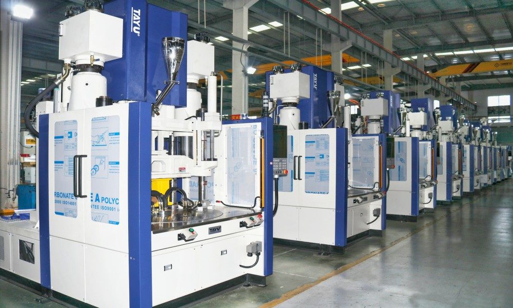 Row of vertical injection moulding machines on a production floor